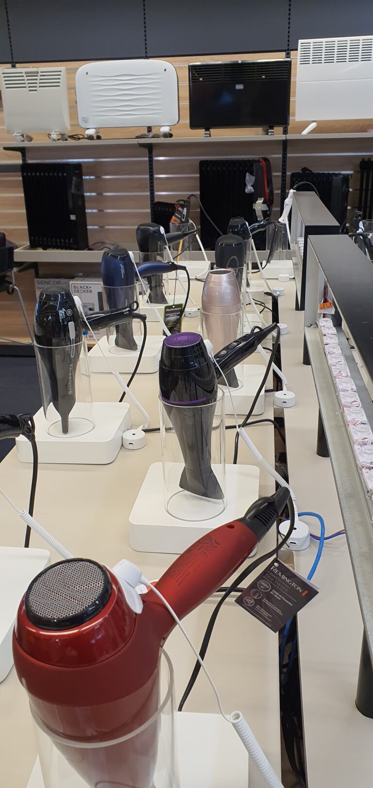 Les sèche-cheveux sont fixés et attachés aux présentoirs afin d'empêcher les vols et la criminalité organisée dans le commerce de détail.