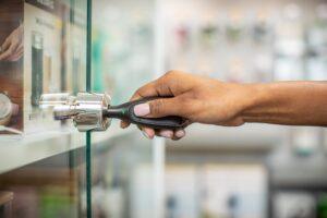 Main utilisant un OneKEY pour ouvrir une serrure sur une vitrine d'exposition