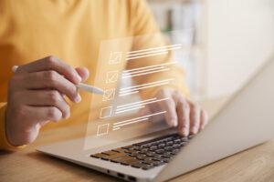 Un responsable de magasin remplit une liste de contrôle d'audit de prévention des pertes sur un ordinateur portable.