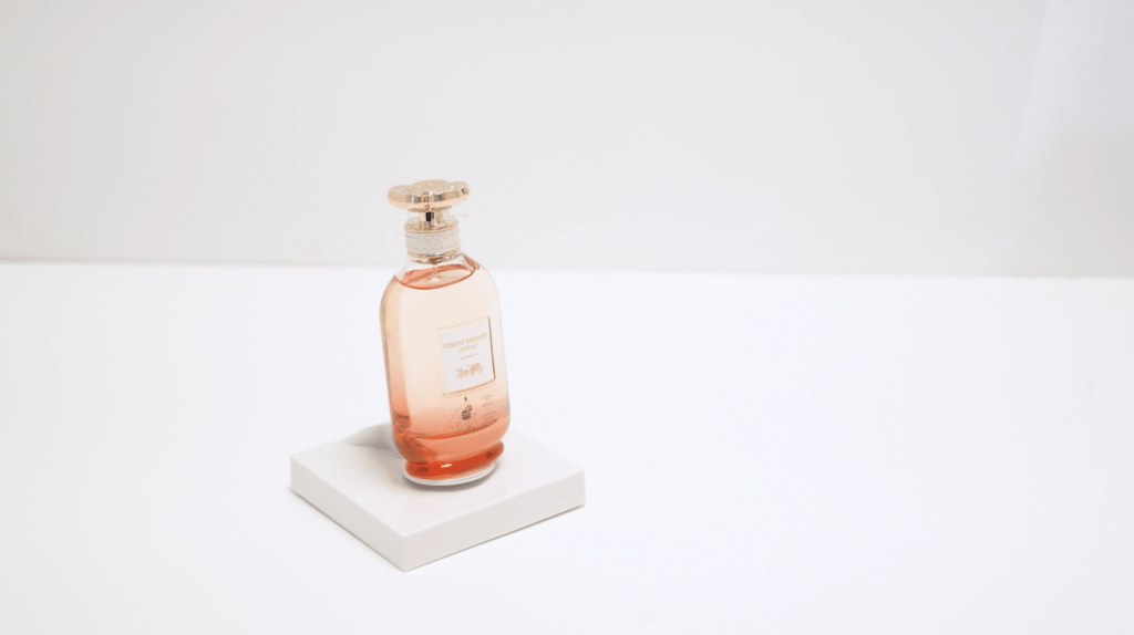 Échantillonneur de parfum monté sur une dalle « InVue », un présentoir carré discret, sur une surface blanche