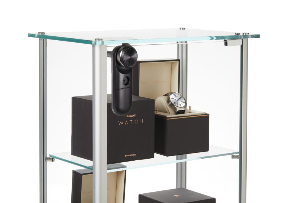InVue LIVE Cam Lock fixées sur une vitrine en verre pour maintenir en place les montres connectées emballées sur les étagères d'exposition