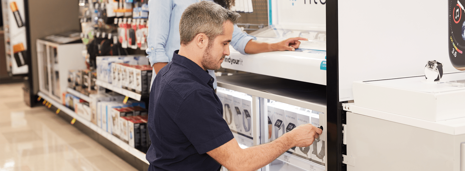 Un vendeur installe un présentoir en toute sécurité dans un hypermarché