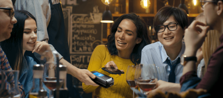 Groupe de personnes assises avec des verres à vin et mPOS