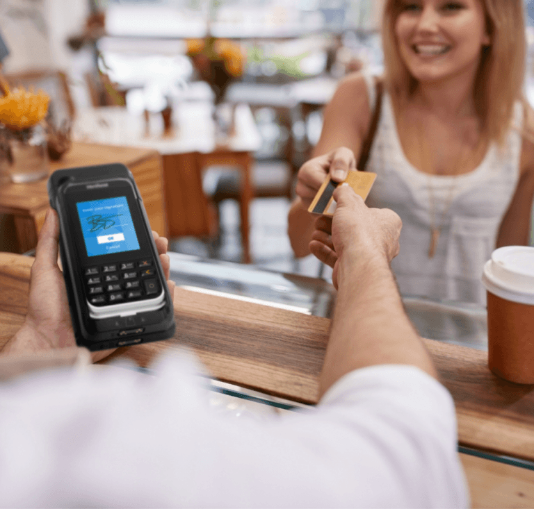 Femme tendant une carte de crédit à un travailleur tenant un mPOS