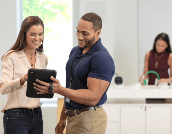 Homme et femme regardant une solution mPOS dans un magasin de détail