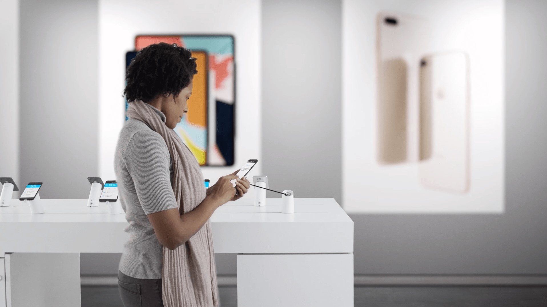 Une femme regarde des téléphones portables sécurisés dans un magasin de vente au détail de téléphones portables.