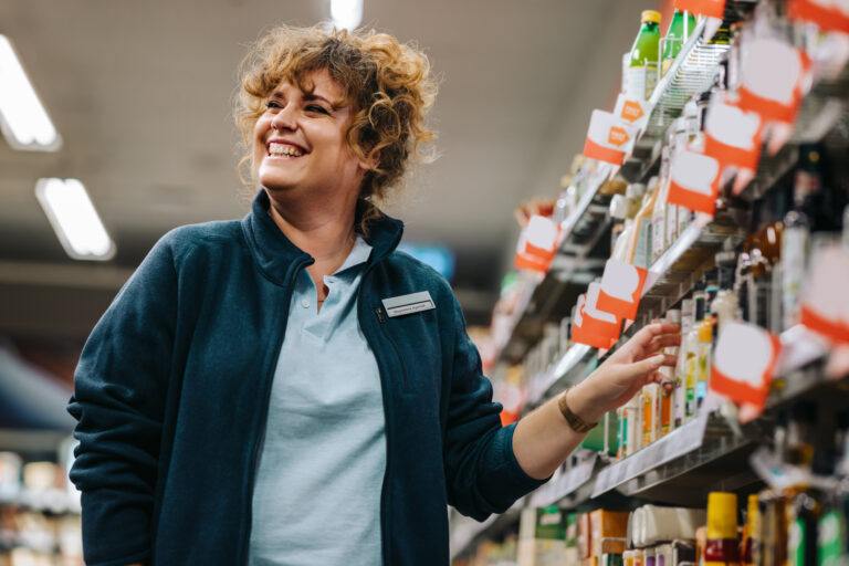 Femme d'affaires confiante près des rayons et souriante dans un supermarché. Femme gérante d'une épicerie.