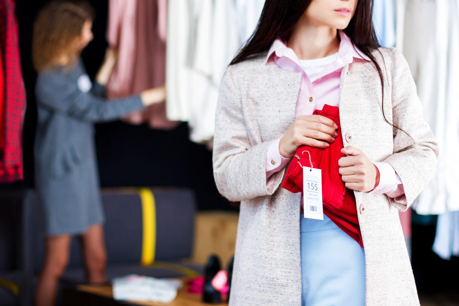 Gros plan sur une jeune femme qui vole un jean rouge